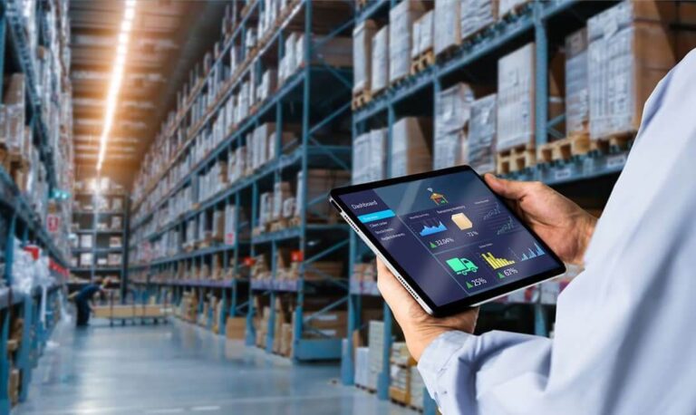 A warehouse worker using an iPad to keep track of inventory while in an aisle inside a warehouse