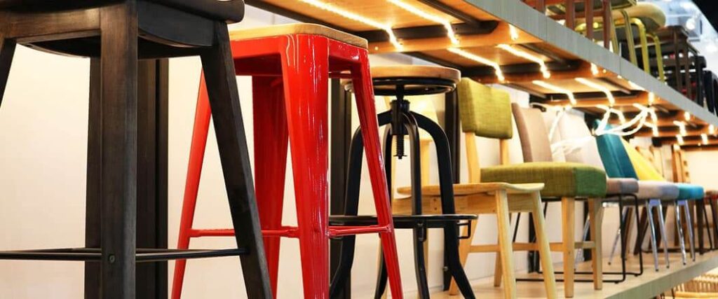 Long row of chairs and stools on display of different designs